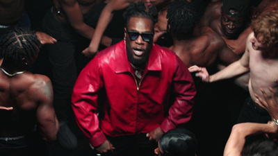 a man in a red jacket surrounded by people