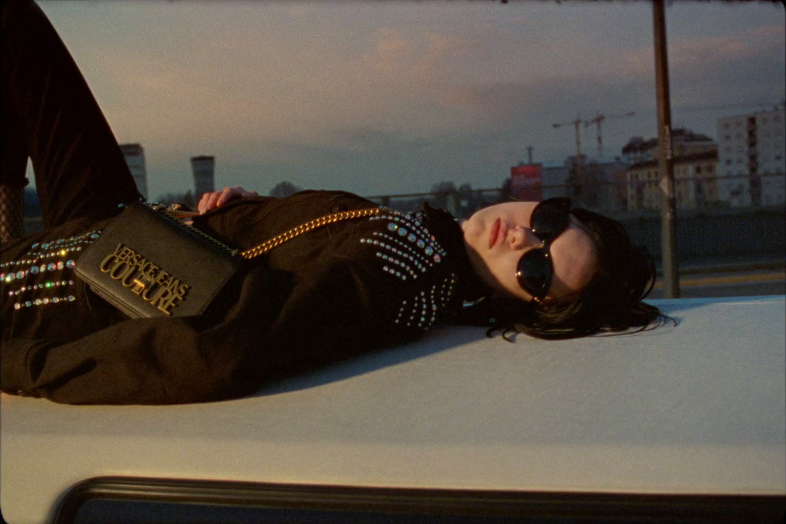 a woman laying on the hood of a car