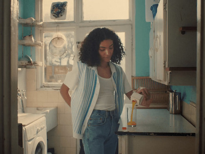 a woman standing in a kitchen next to a washing machine