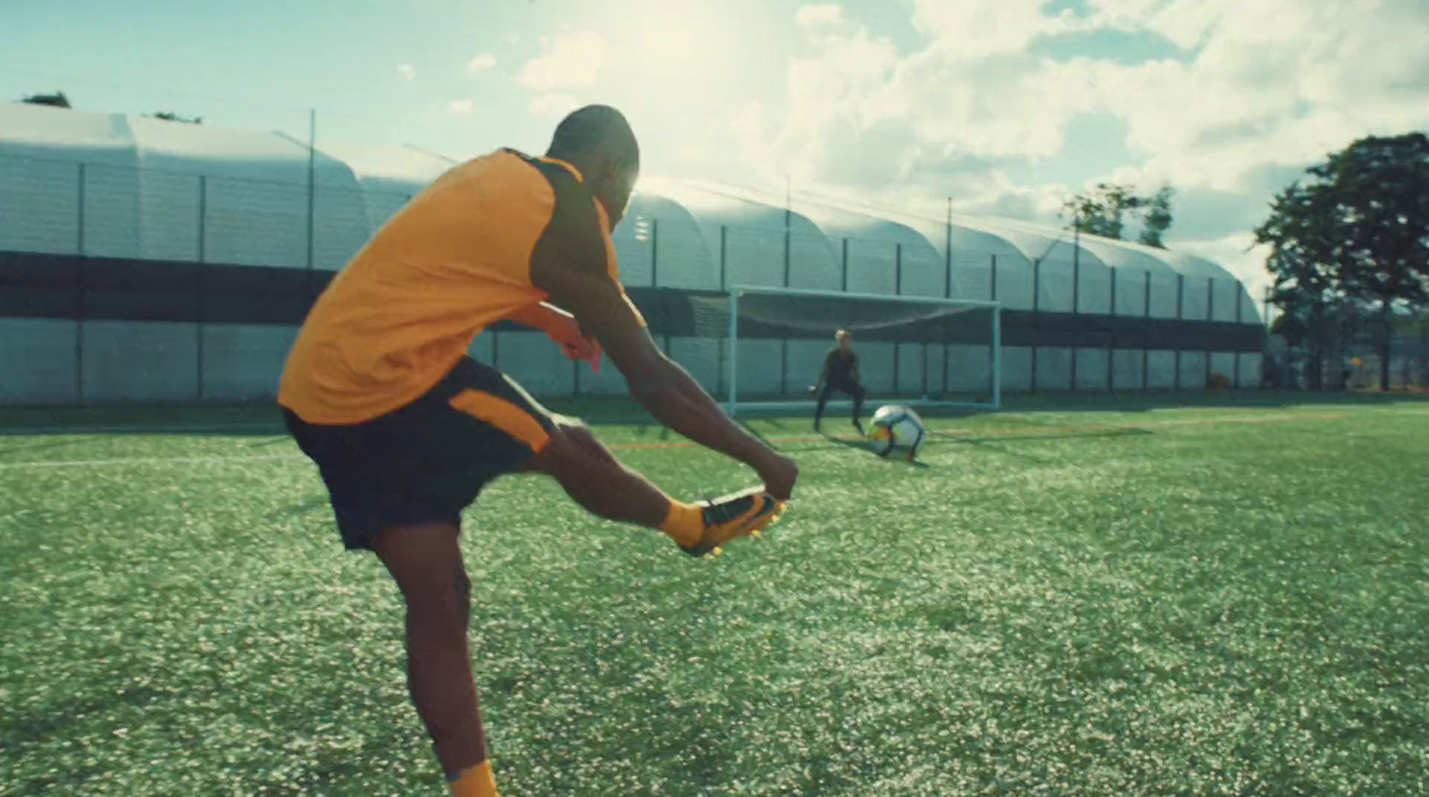 a man kicking a soccer ball on top of a field