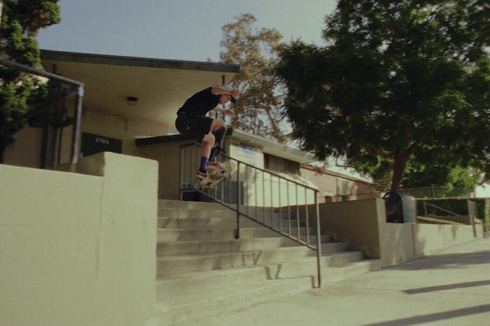 a man riding a skateboard down the side of a set of stairs