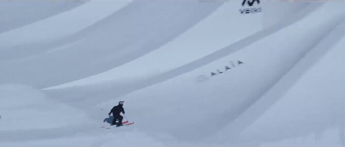 a man riding a snowboard down a snow covered slope