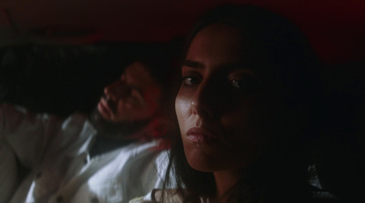 a man and a woman sitting in the back of a car