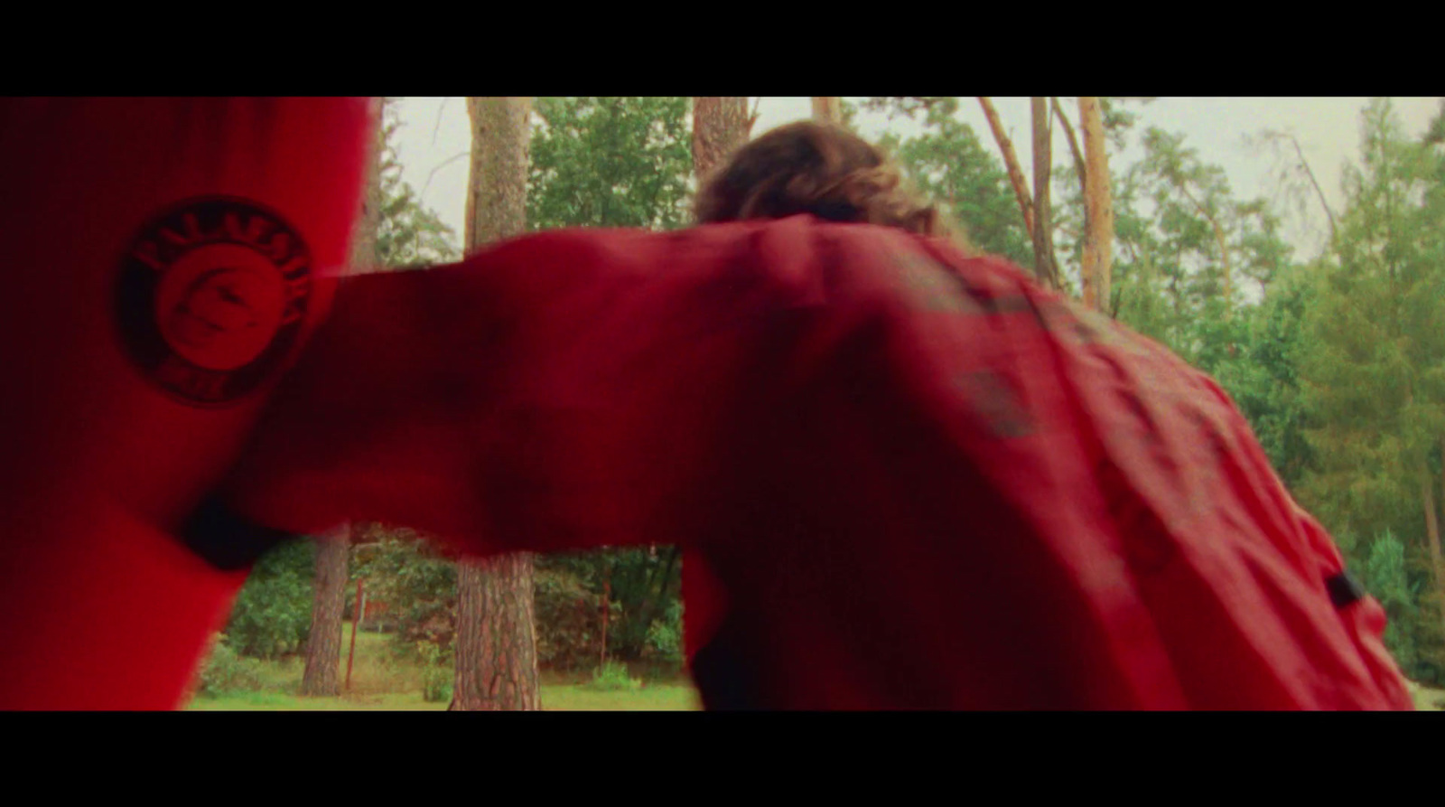 a person in a red jacket is punching a punching bag