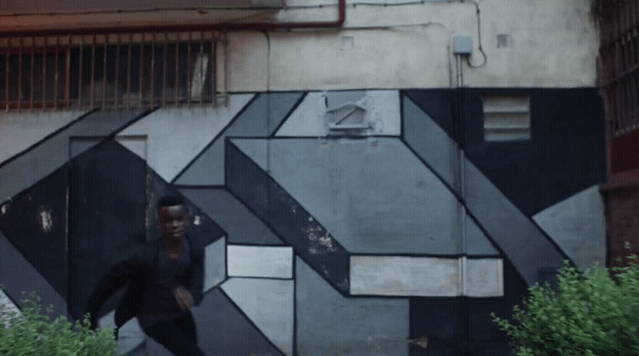 a man walking down a street next to a building