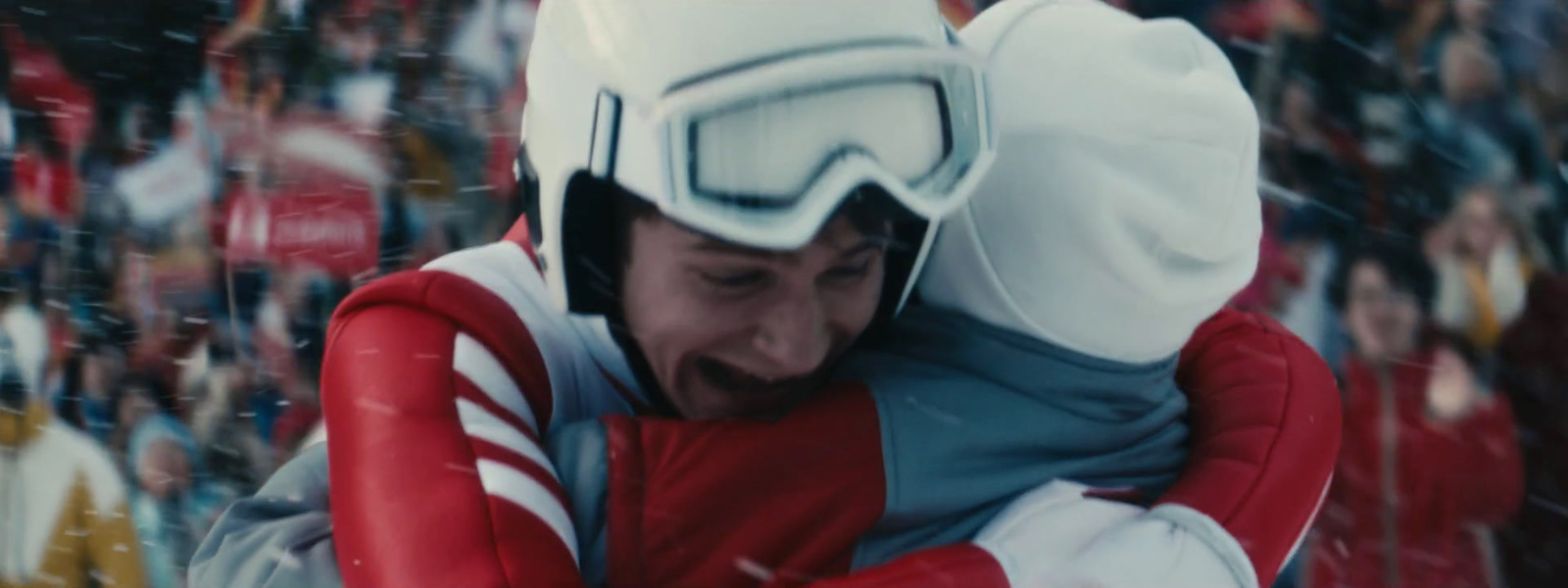 a man in a red and white ski suit hugging another man