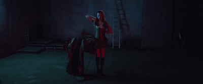 a woman standing in a dark room holding a frisbee