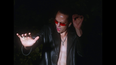 a man in a leather jacket and red sunglasses