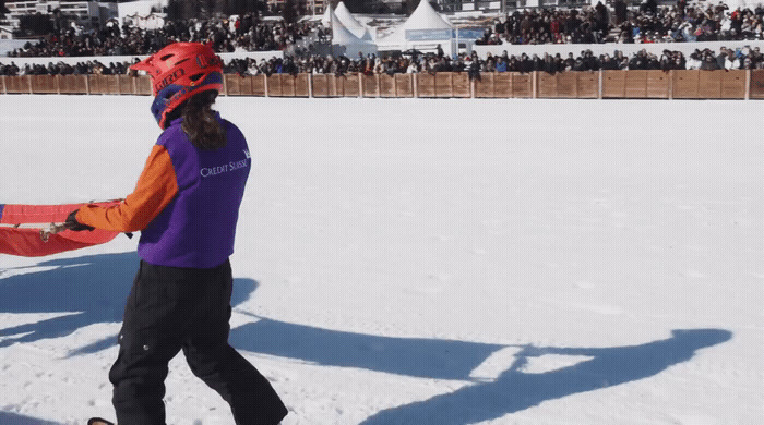 a person in a purple jacket and a red snowboard