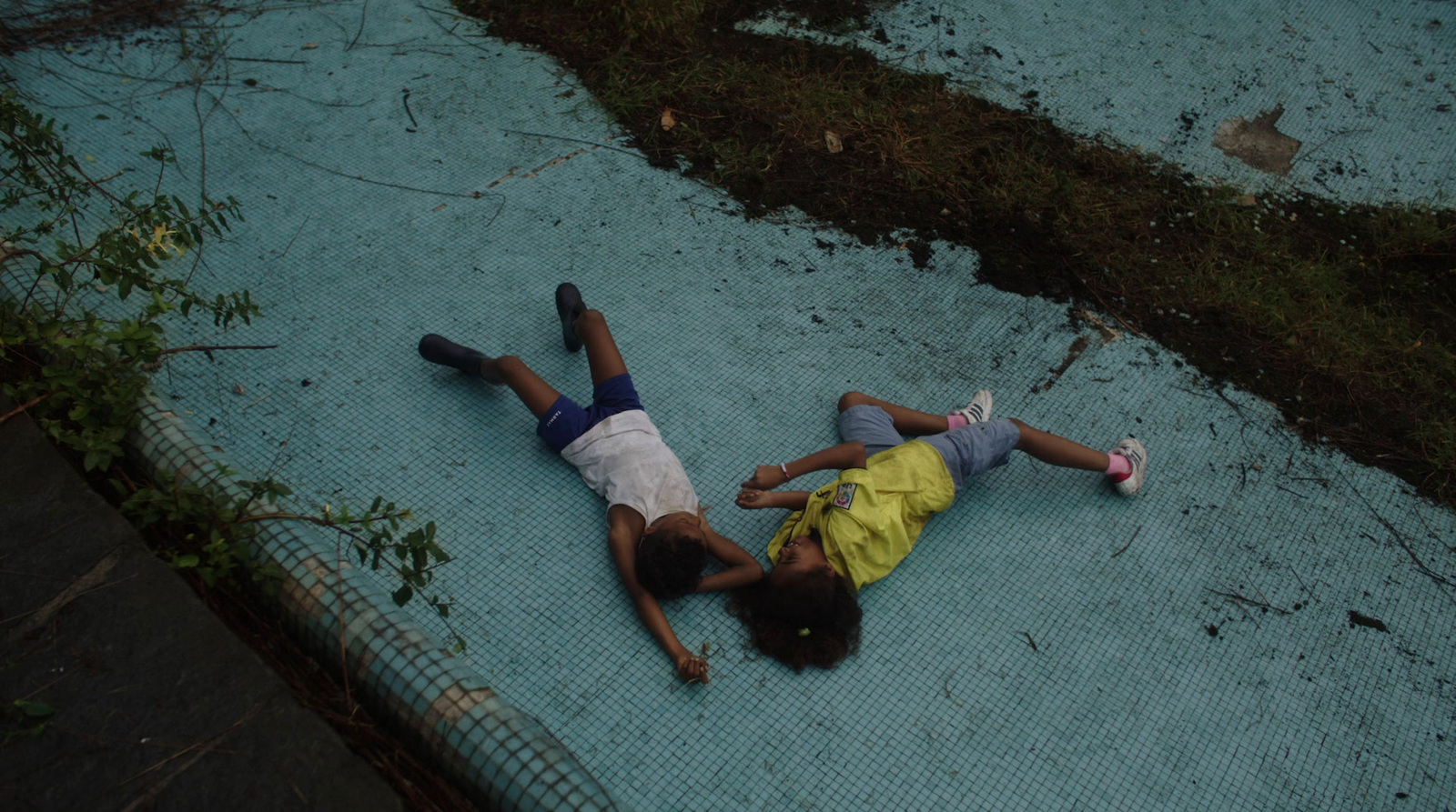 a couple of people laying on top of a blue tarp