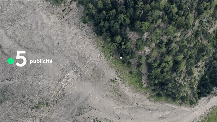 an aerial view of a dirt road in the middle of a forest