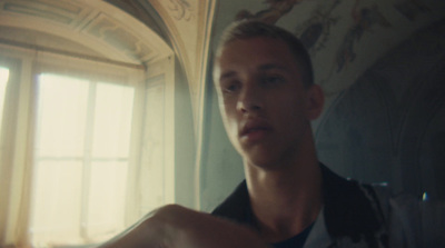 a young man sitting in front of a window