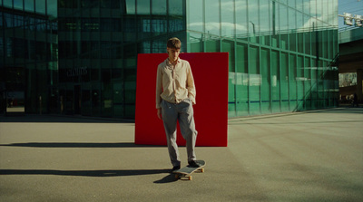 a man standing on a skateboard in front of a building