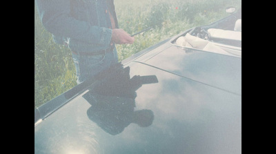 a man standing next to a car holding an umbrella