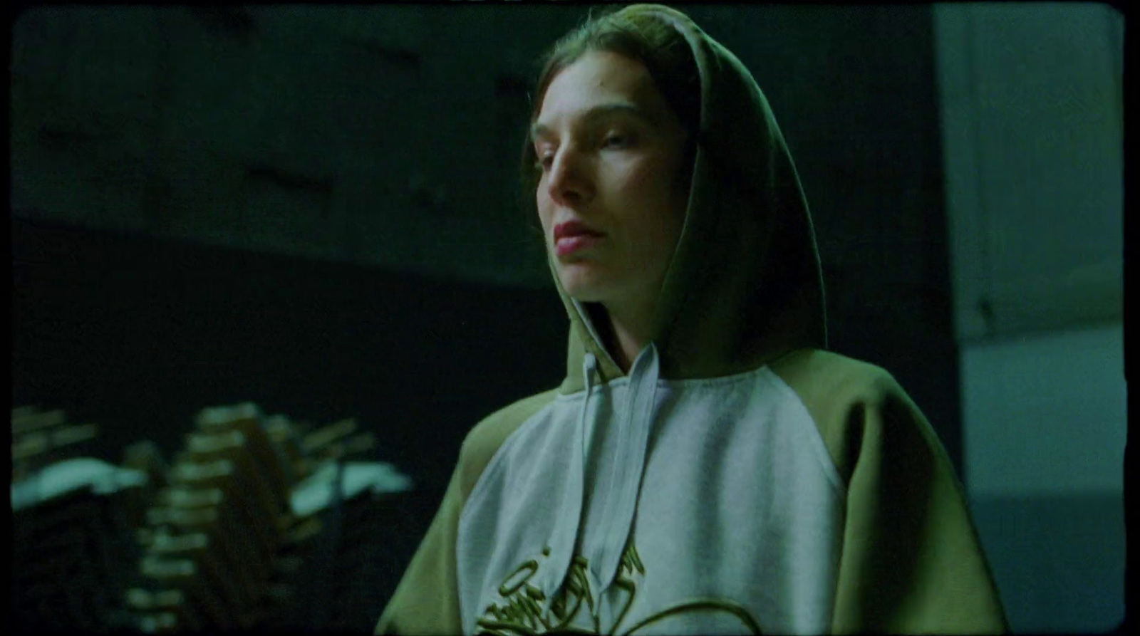 a woman wearing a hoodie in a dark room