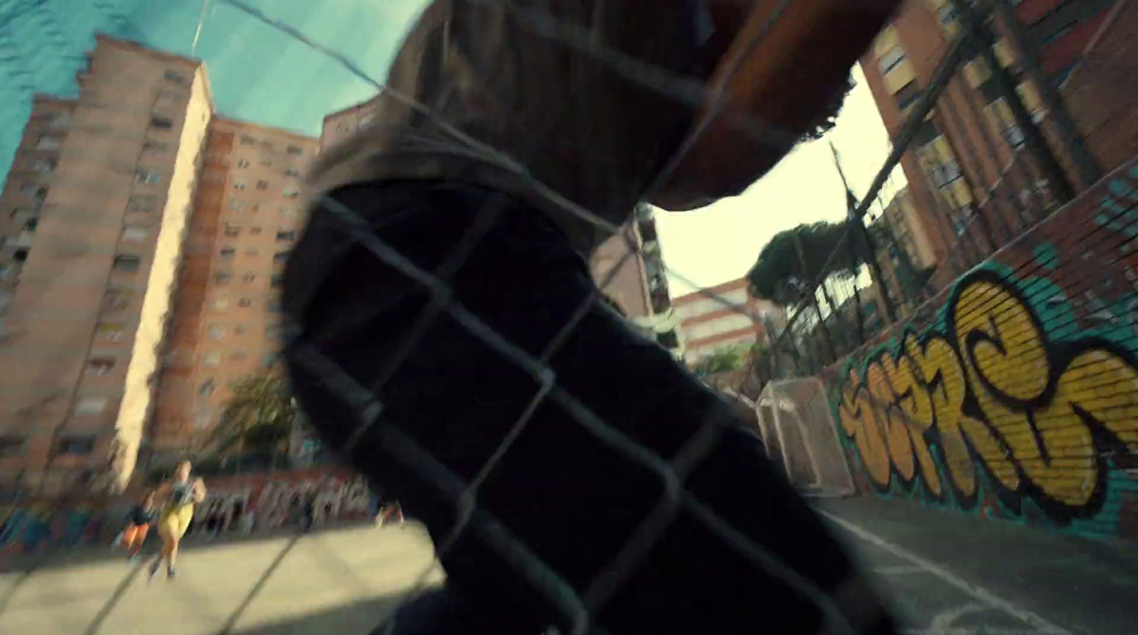 a man riding a skateboard down a street next to a fence