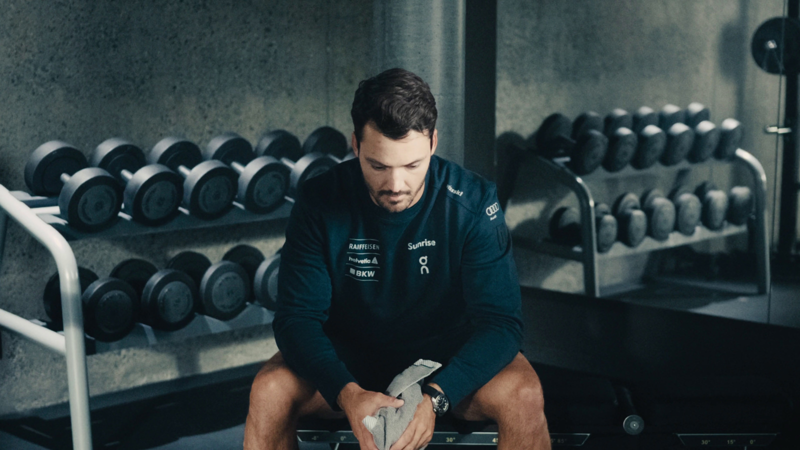 a man sitting on a bench in a gym