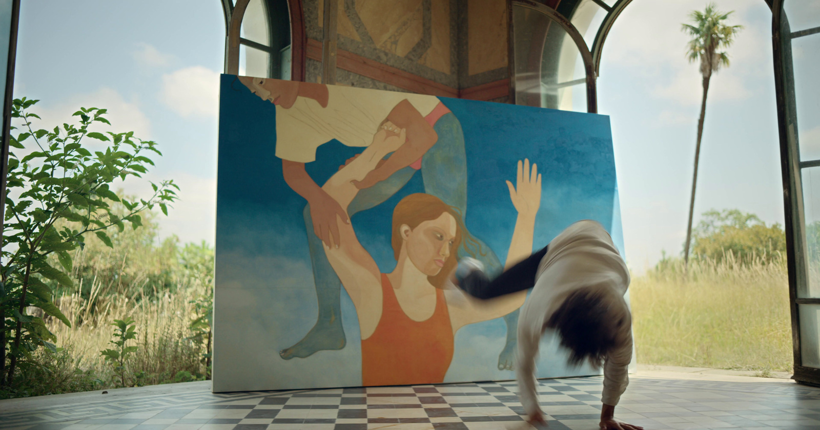 a dog standing in front of a painting of a woman