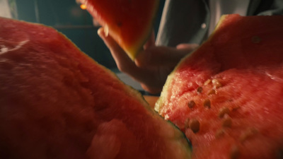 a close up of a person cutting a piece of watermelon