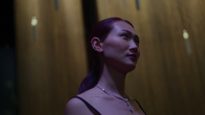 a woman standing in front of a wooden wall