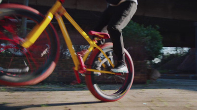 a person riding a yellow bike on a sidewalk