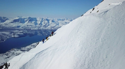 a group of people climbing up the side of a snow covered mountain