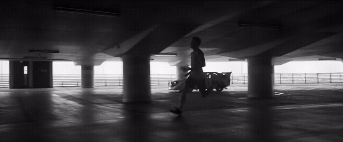 a man walking through an empty parking garage