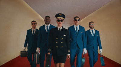 a group of men in suits and sunglasses walking down a hallway