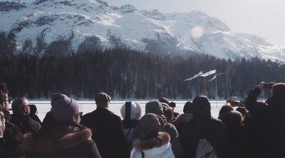 a group of people standing in front of a snow covered mountain