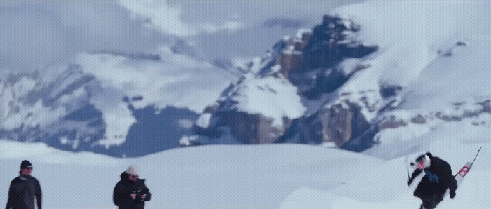 a group of people standing on top of a snow covered slope