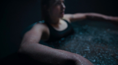 a woman in a black tank top in a bathtub