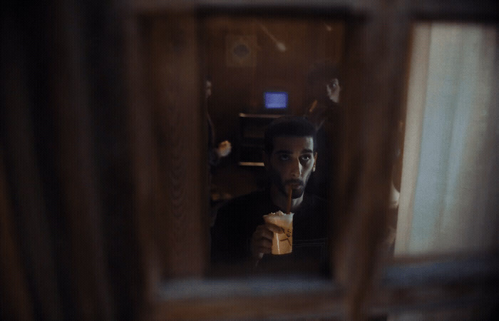 a man in a tuxedo eating a sandwich