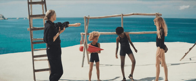 a group of women standing on top of a sandy beach