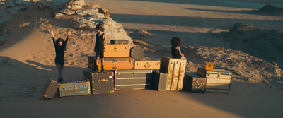 a group of people standing on top of a pile of luggage