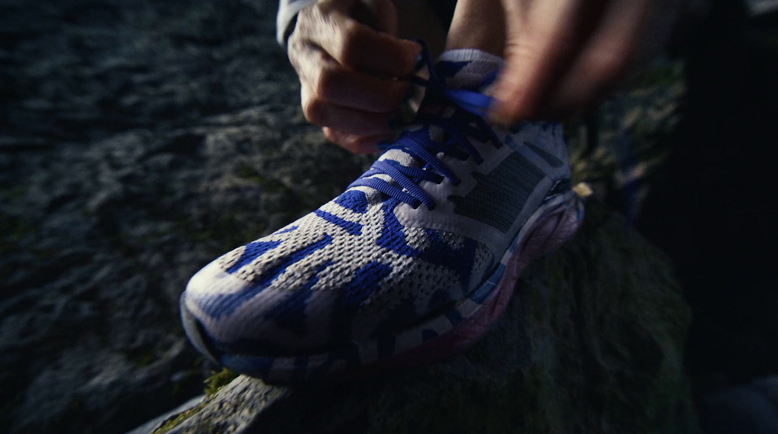 a person tying a shoelace on a rock