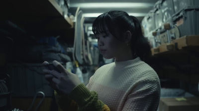 a woman looking at a cell phone in a warehouse