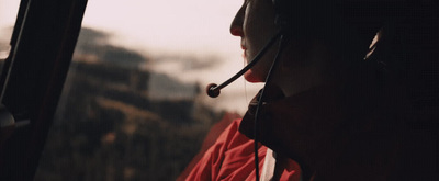 a woman wearing a headset is looking out a window