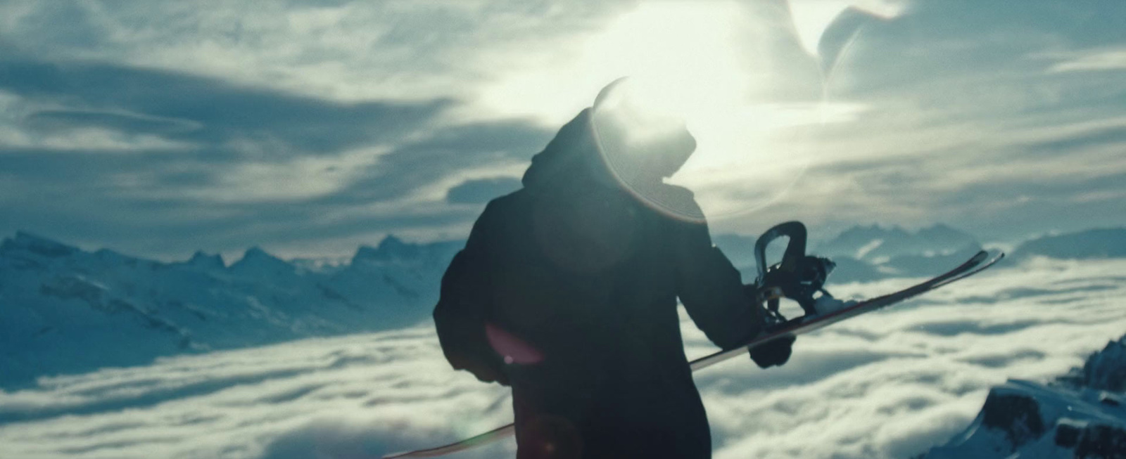 a person with a snowboard standing on a mountain