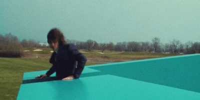 a person sitting on a blue surface in a field