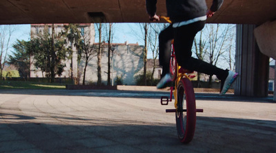 a person riding a bike under a bridge