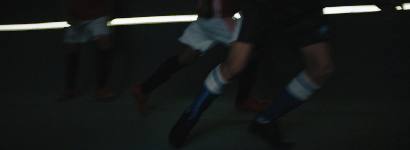 a group of people playing soccer in a dark room