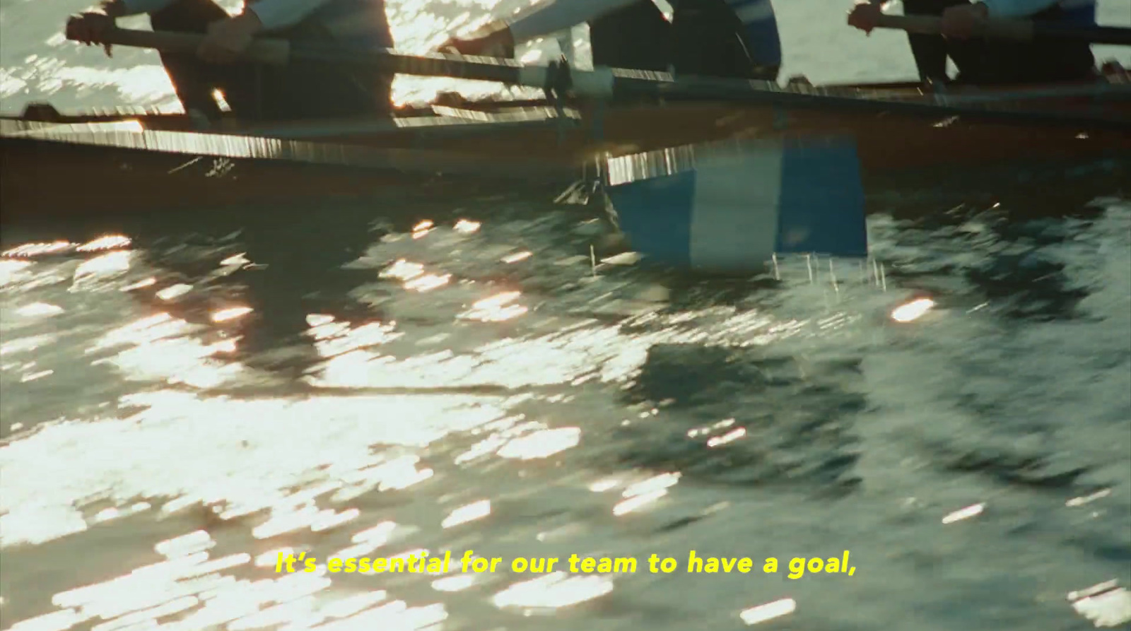 a group of people rowing a boat on a body of water