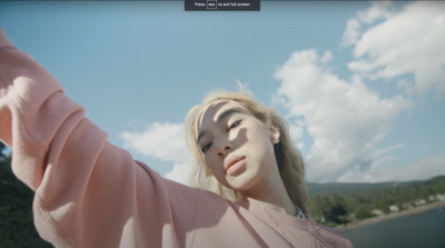 a girl is taking a selfie in front of a lake