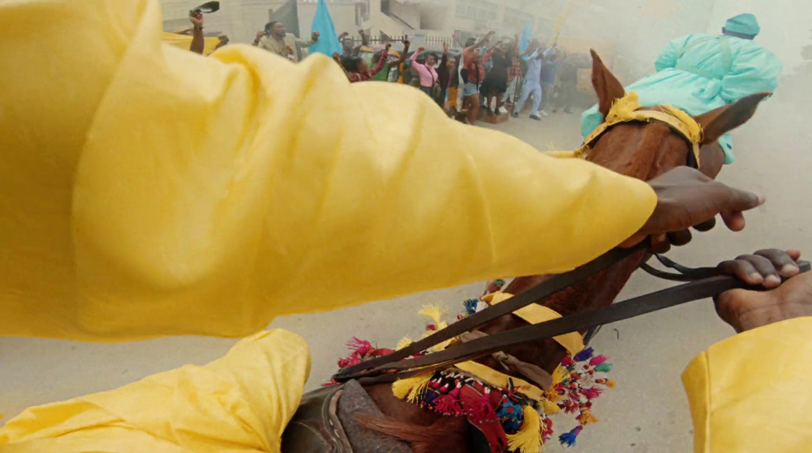 a person in a yellow outfit is holding a horse