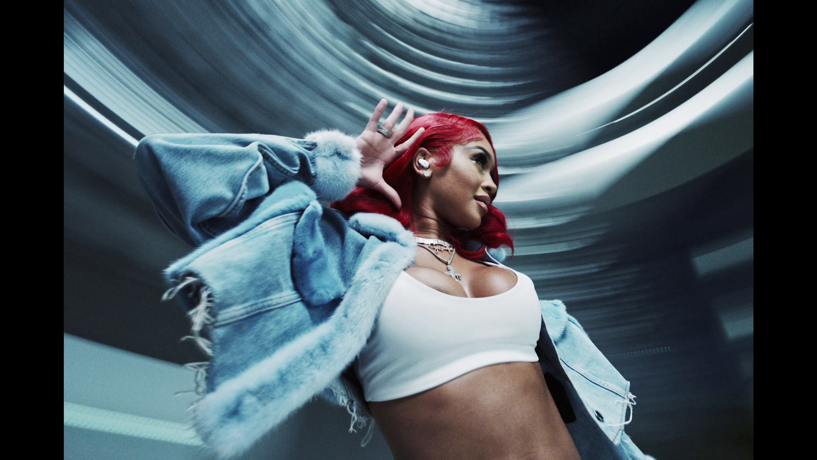 a woman with red hair wearing a white top and denim jacket