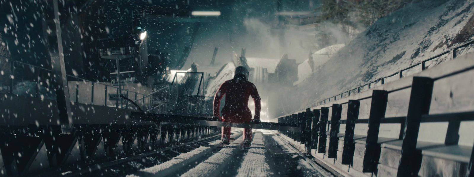 a man walking across a bridge in the snow