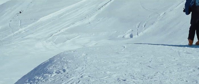 a man standing on top of a snow covered slope