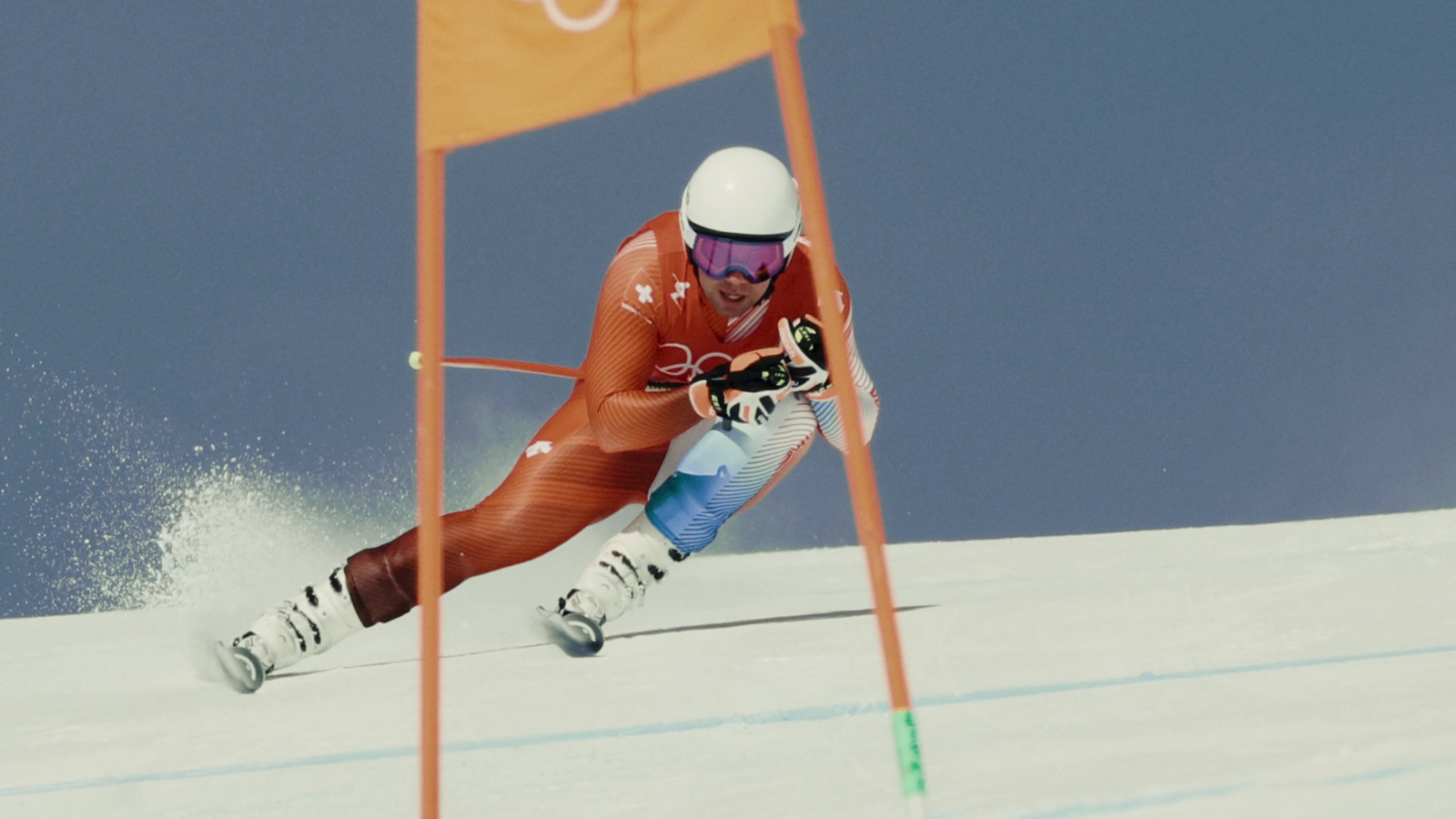 a man riding skis down the side of a snow covered slope