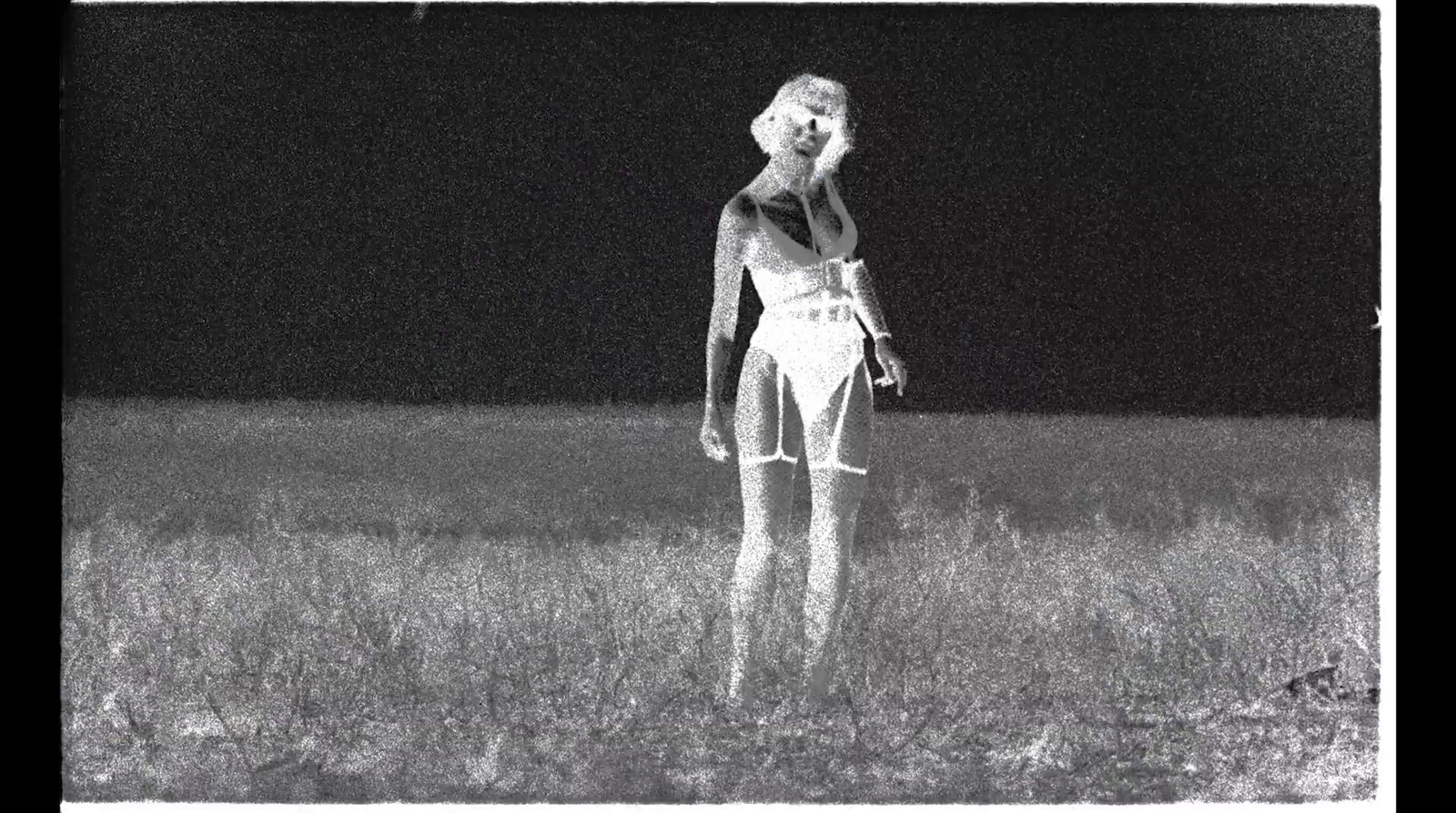 a black and white photo of a woman in a field