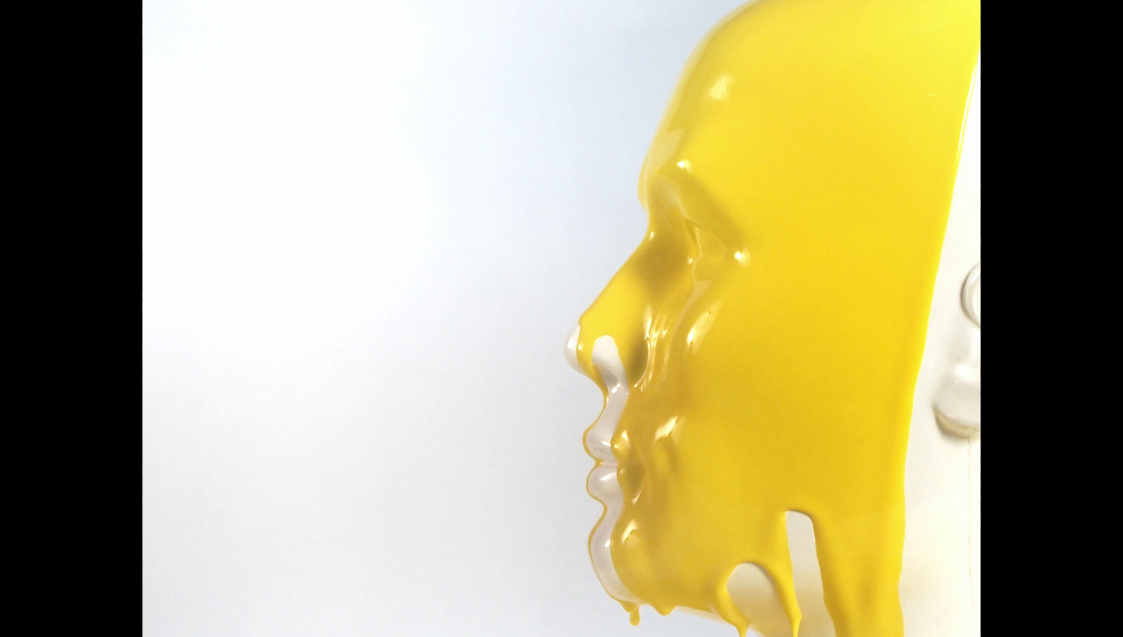 a close up of a yellow liquid dripping on a white surface